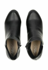 Czarne botki za kostkę wykonane z gładkiej skóry, z szpiczastym noskiem i suwakiem z boku, charakteryzujące się eleganckim designem i przeszyciami.