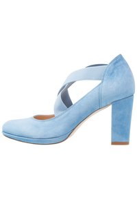 Chaussure à talon haut en suede bleu clair avec un bout arrondi et des sangles élastiques croisées. Design à talon carré pour plus de stabilité. Texture lisse.