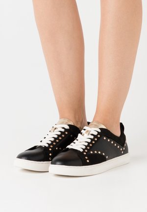 Sneaker in pelle e suede neri con accenti dorati, dettagli borchiati, lacci bianchi e suola in gomma piatta. Senza motivi distintivi.
