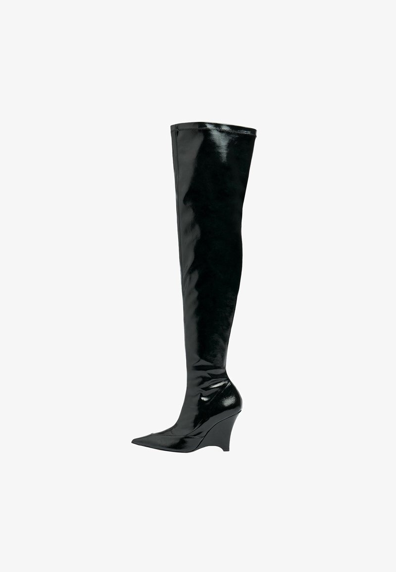 Bota de mujer negra brillante, de caña alta hasta la rodilla, con puntera afilada y tacón cuña, de diseño elegante y ajustado que se extiende por encima de la rodilla.