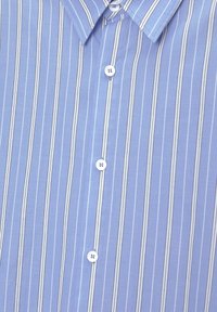 Chemise bleu clair à rayures comprenant des rayures verticales blanches et bleu foncé, un col pointu et des boutons blancs le long de la patte de boutonnage.