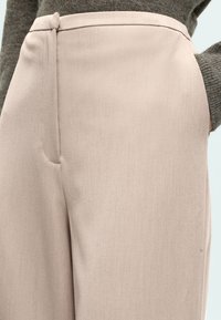 Ροζ ροζ tailored παντελόνια από λείο ύφασμα, με διακριτική λάμψη, καθαρές γραμμές και πλαϊνές τσέπες. Το στρίφωμα και η μέση είναι καλοραμμένα.