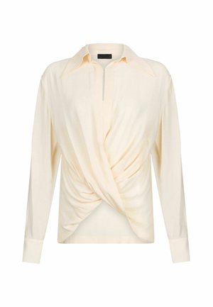 Camicia a maniche lunghe color crema con design avvolgente, caratterizzata da un colletto a punta, patta frontale e tessuto liscio e texture.