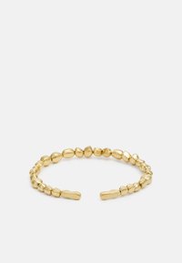 Bracciale a maniche in tono oro con una serie di perle lisce e rotonde. Le estremità sono incise con il nome del marchio "GUESS."