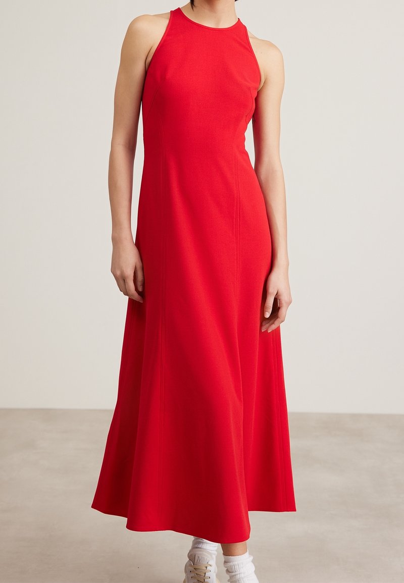Robes maxi sans manches rouges avec un corsage ajusté et une jupe évasée, fabriquées en un matériau lisse. Design simple sans motifs ni embellissements.