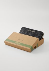 Black wallet with a textured surface and "Valentino" embossed. Packed in a brown cardboard box with green accents and recycling message.