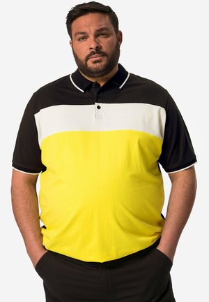 Kortærmet polo-shirt med horisontale striber i sort, hvid og gul, med krave, knaplukning og kontrastdetaljer.