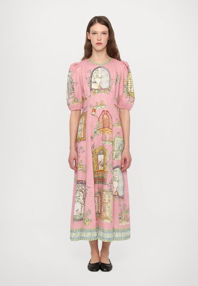 Roze jurk met opgestoken mouwen, voorzien van kleurrijke deurillustraties en bloemenpatronen. Zoom versierd met groene accenten. Eenvoudige zwarte schoenen.