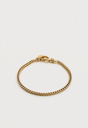 Guldkedjearmband med en vriden design, med en hummerlås och små dekorativa detaljer nära låset. Slät metallisk struktur.