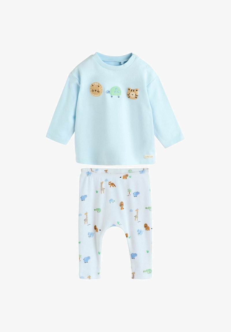 Ensemble bébé bleu clair avec des appliqués de lion, tortue et tigre sur le haut, et un pantalon imprimé animalier avec des girafes, éléphants, lions et crocodiles.