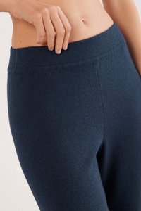 Marinblå stickade leggings med en bred, slät midjeresår och en mjuk textur, som framhäver en nära passform runt midjan och låren.