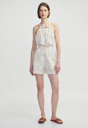 Helles beiges Jumpsuit mit einem gefalteten Oberteil, elastischem Bund und kurzen Shorts. Verfügt über dezente strukturierte Muster und dünne Träger.