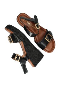 Zwarte leren wedge sandalen met dubbele verstelbare bandjes, gouden gespen, textuur zwart plateau en bruine gewatteerde binnenzool.