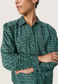 Groen patroon shirt met een zwart roosterontwerp, voorzien van een klassieke kraag, knoopsluiting en ge gathered mouwen. Gladde textuur.
