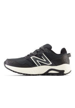 Sort-hvid atletisk sneaker med polstret sål, mønstret overdel og stort hvidt "N"-logo på siden.