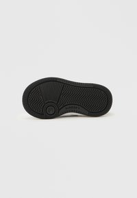 Fekete gumitalp cipő talp, cikk-cakk mintával, kör alakú tapadórésszel és logós felirattal. Simább textúra kiemelkedő tapadási részletekkel.