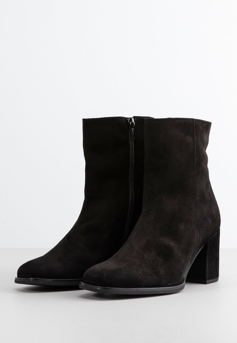 Czarne zamszowe botki za kostkę z okrągłym noskiem, bocznym zipperem oraz masywnym wysokim obcasem dla stabilności. Gładka tekstura z matowym wykończeniem.