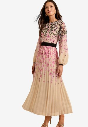 Vaakukangas maxi-mekko beige värissä, jossa on vaaleanpunaisia ja mustia kukkakuvioita, pitkät hihat ja musta vyötärö. Sileä, kevyt kangas.