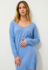 Světle modré cashmere šaty svetr s žebrovanými rukávy a lemem, s výstřihem ve tvaru lodi a měkkým, texturovaným materiálem.
