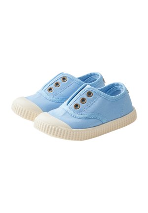 Blue canvas slip-on shoes with a rubber sole, featuring three metal eyelets and a textured white midsole.