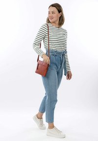 Maglietta a maniche lunghe a righe, jeans in denim leggeri a vita alta, borsa a tracolla marrone e sneakers bianche. Outfit casual con vestibilità rilassata.