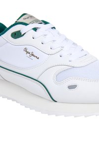 Sneaker bianco con accenti verdi, materiali in pelle e rete, punta tonda, lacci piatti, suola imbottita e logo del marchio sul lato.