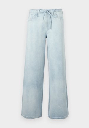 Φαρδύ παντελόνι από τζιν σε ανοιχτό γαλάζιο χρώμα με εμπρόσθιες τσέπες και υφασμάτινη ζώνη στη μέση, απεικονίζεται σε απλό φόντο.