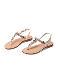 Sandali in oro con design della parte superiore decorato da perline, suola piatta e cinturino alla caviglia regolabile. Soletta nude liscia con un accento in legno sul tallone.