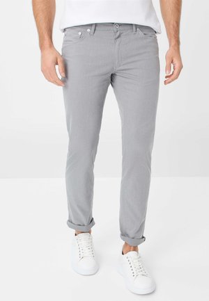 Light gray pants with a slim fit, featuring a smooth texture and rolled cuffs, paired with white sneakers. Classic design with front pockets.