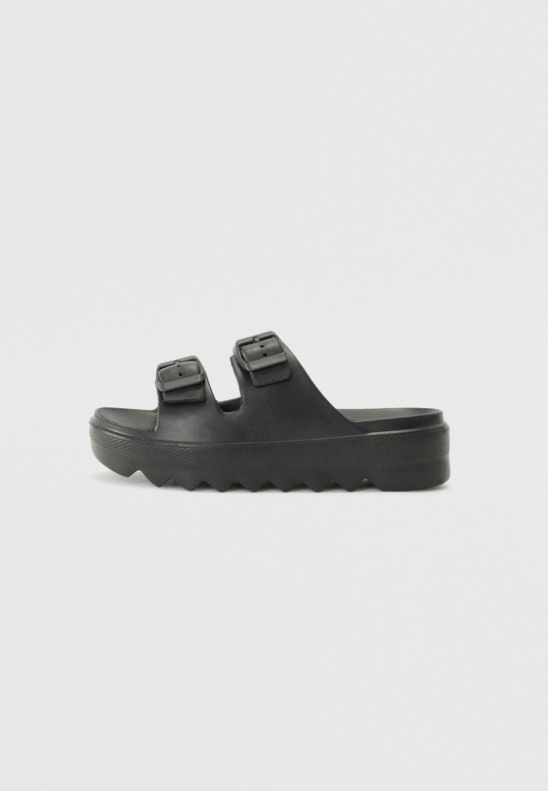 Black rubber sandals featuring two adjustable buckles, a textured footbed, and a thick, zigzag sole for added grip and comfort.