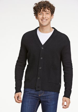 Zwarte cardigan met een V-hals, geribbelde kraag, knoopsluiting en twee voorzakken. Gemaakt van zacht materiaal en heeft een standaard pasvorm.