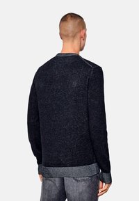 Suéter oscuro con un acabado texturizado, cuello y puños acanalados. Presenta un diseño de color sólido sin patrones ni adornos.