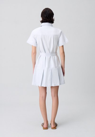Robe chemise bleu pâle à manches courtes avec une taille ceinturée, jupe plissée et col. Tissu en coton lisse, vue de l'arrière ouverte.