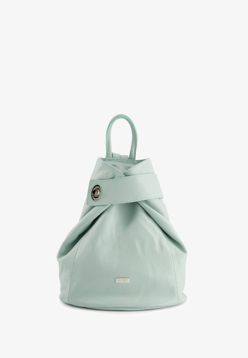 Light mint green leather bag with a twisted design, featuring a circular silver hardware accent and a top handle for carrying.