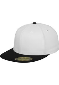 Hvid fitted cap med sort skygge og topknap. Har en flad skygge og et gult mærke, der angiver "210 Fitted Flexfit Tech."