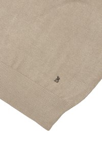 Jasnobeżowy sweter o gładkiej teksturze, prążkowany dół i małe czarne logo na dolnej krawędzi. Prosty, klasyczny design.