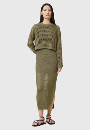 Set a due pezzi in verde oliva lavorato a maglia, composto da un maglione corto e una gonna lunga con spacchi laterali, caratterizzato da una tessitura aperta e una finitura testurizzata.