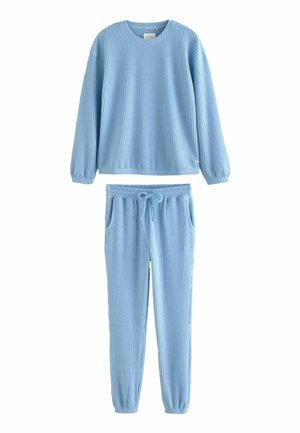 Svetle modrý žebrovaný loungewear set, který obsahuje dlouhý rukáv top s kulatým výstřihem a elastickými manžetami, doplněný o odpovídající kalhoty na stažení s kapsami.
