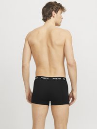 Schwarze Boxershorts aus elastischem Material, mit einem elastischen, gebrandeten Bund und einer körperbetonten Passform. Sichtbare Nähte an den Säumen setzen Akzente.