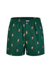 Zelené bavlněné boxerky s opakujícím se vzorem perníkových figurek v červených čepičkách; elastický pás a detail s knoflíkovým zapínáním.