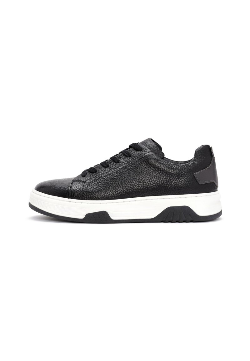 Sneaker basse in pelle nera con texture, lacci neri e suola spessa bianca con battistrada nera su sfondo bianco.