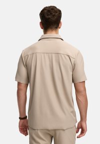Korte mouwen, beige shirt met verticale strepen, een kraag en een relaxte pasvorm. Zachte textuur met een gladde afwerking, ontworpen voor comfort.