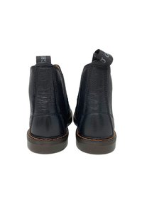 Stivali alla caviglia in pelle nera con superficie texture, cuciture a contrasto e linguette sul retro per una facile indossatura. Suole in gomma piatta.