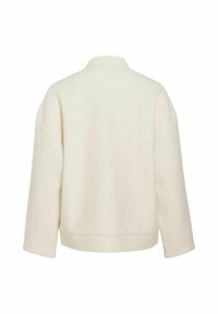 Veste surdimensionnée couleur crème avec une texture douce, col, larges manches et un design minimaliste, idéale pour le superposition.