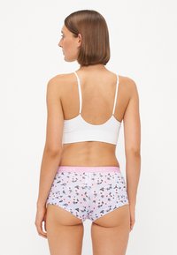 Witte geribbelde bralette gecombineerd met roze met bloemmotief hipster slips met een zachte tailleband en een bloemdessin in pastelkleuren.