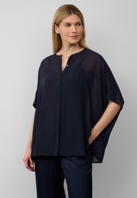 Marineblaue, leichte Bluse mit kurzen Dolmanärmeln, einer geknöpften Leiste und einer lockeren Passform, aus durchsichtigem Stoff mit glatter Textur.