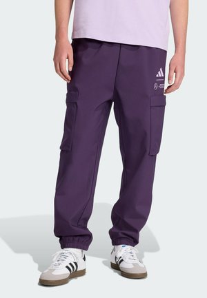 Lila Cargo-Hosen mit elastischen Bündchen, seitlichen Taschen und weißen Logo-Akzenten. Hergestellt aus strapazierfähigem Stoff und mit lockerem Schnitt.
