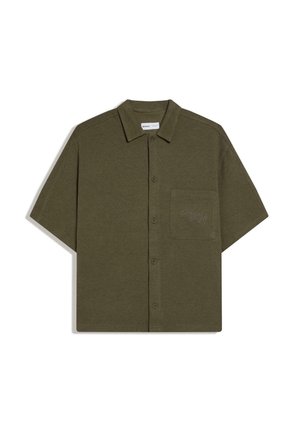 Chemise à manches courtes vert olive avec col et poche poitrine affichant un texte brodé subtil.