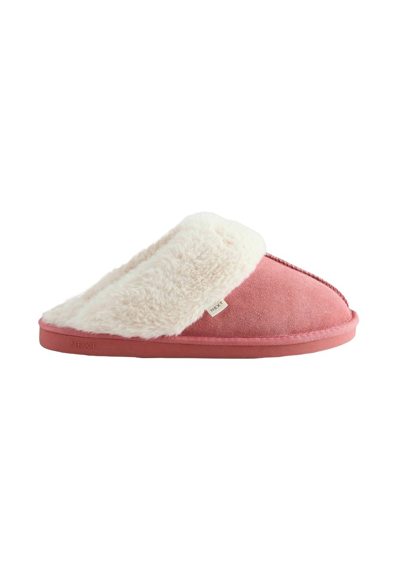 Pink suede slipper with a white faux fur lining, open back design, contrasting stitching, and a subtle brand tag on the side.