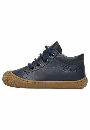 Baskets enfant en cuir bleu marine avec semelle en caoutchouc marron, bout arrondi et lacets bleu marine sur fond blanc.